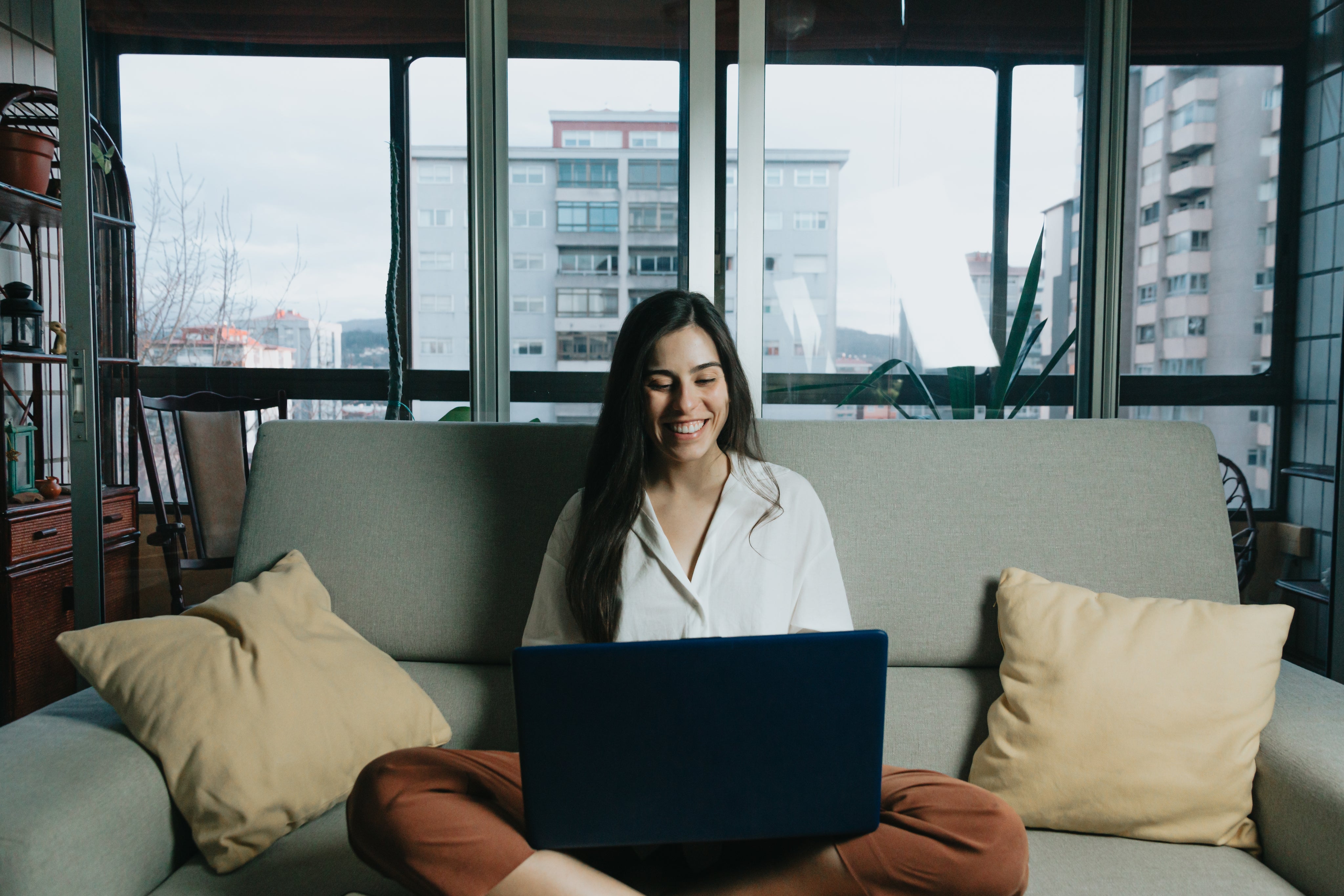 woman-sits-on-a-couch-while-looking-at-laptop.jpg